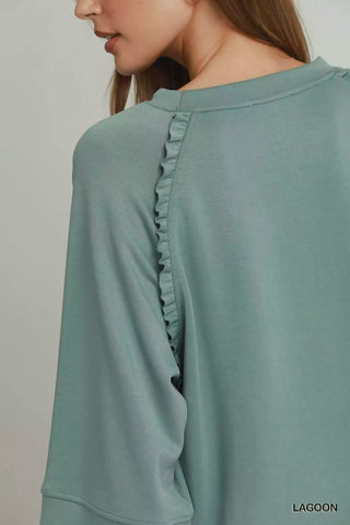 Close-up of the Umgee Lagoon top's neckline and ruffle-trim shoulder seam.
