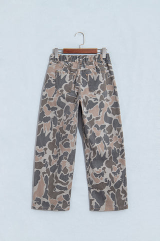 Back of camouflage ankle-length jeans on a hanger, showing rear patch pockets and gathered waistband.