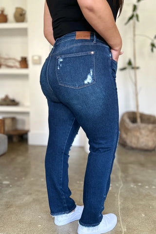 Rear three-quarter view of Judy Blue 88819 jeans showing distressed back pockets and raw hems.