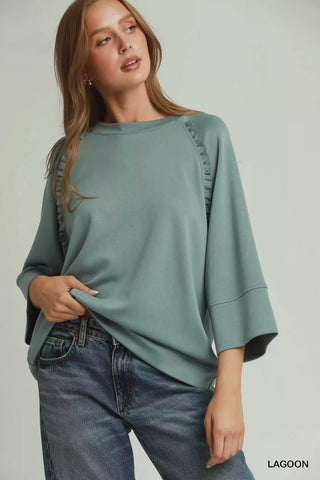 Front view of the Umgee Lagoon top showing ruffle-trim raglan seams and wide three-quarter sleeves.