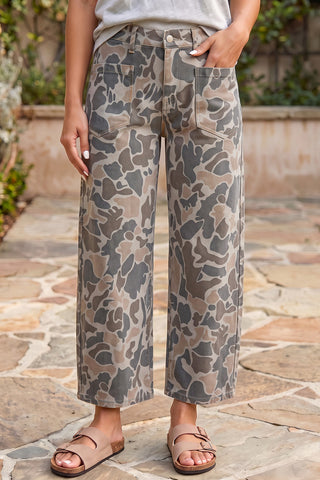 Multicolour camouflage ankle-length jeans styled with a white top and tan sandals.