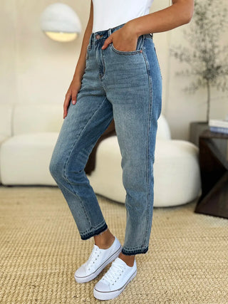 Front three-quarter view of Judy Blue 88818 medium-wash jeans with dark release-hem bands.