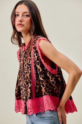 Side-front view of the SO ME leopard blouse showing the pink-trimmed armhole and scalloped hem.