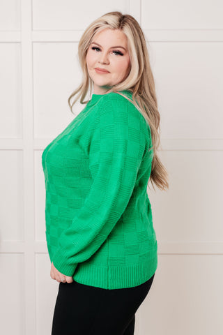 Green Jodifl A Song to Sing checkered-knit pullover, side view showing the ribbed hem.