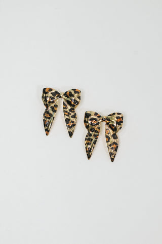 Bow'd & Bold leopard-print bow earrings, pair on a white background.