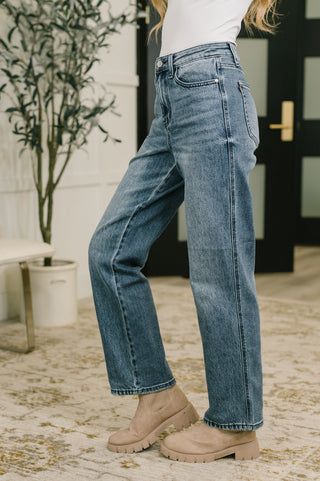 Judy Blue Carlie straight jeans in Everyday Indigo, side view showing the straight leg and stitched hem.