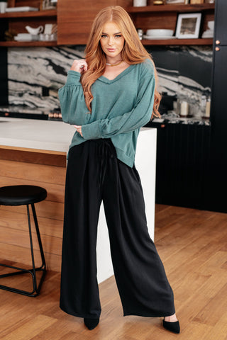 Teal Sew In Love Doesn't Compare V-neck top, full outfit with black trousers and heels.