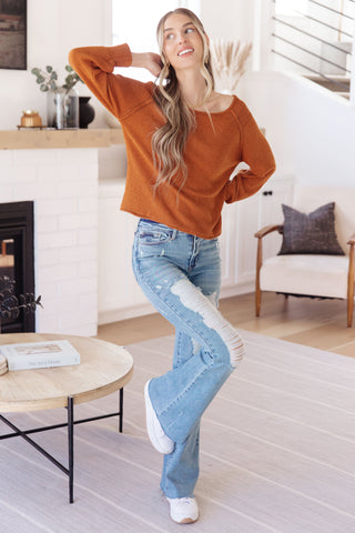 Rust Don't Be Difficult raglan pullover sweater, full outfit with flared jeans.