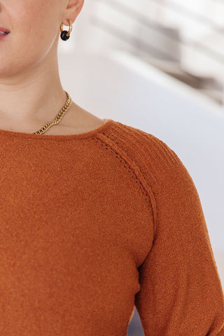 Rust Don't Be Difficult raglan pullover sweater, close-up of the neckline and shoulder seam.