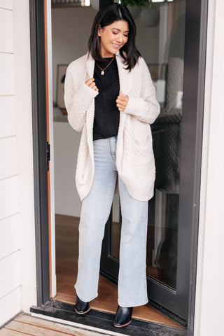 Black Very J Drive Downtown dolman-sleeve top, layered under a cream cardigan.