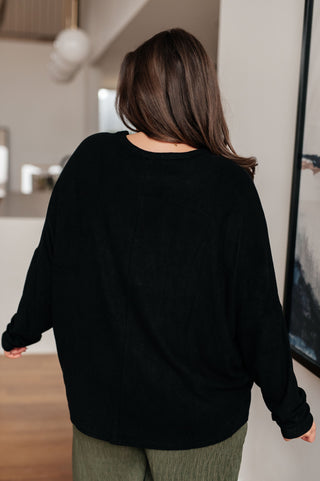 Black Very J Drive Downtown dolman-sleeve top, back view with olive trousers.