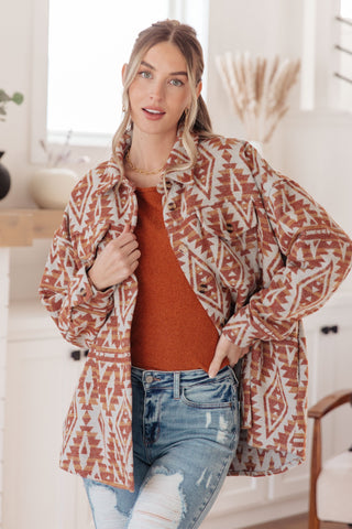 Rust Don't Be Difficult raglan pullover sweater, layered under a patterned jacket.