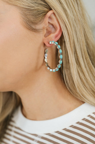 Laguna Luxe silver-tone hoops with turquoise accents, on-ear view showing the oval accents.