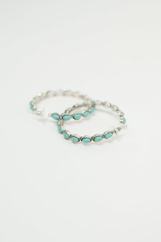 Laguna Luxe silver-tone hoops with turquoise accents, side view of the pair showing the curved shape.