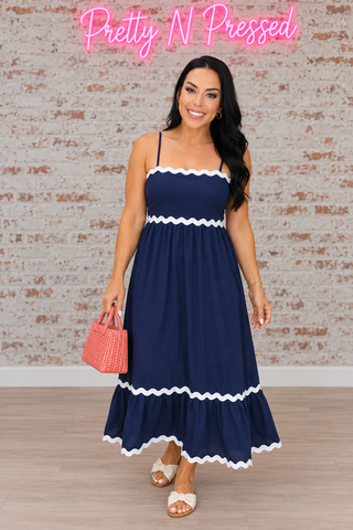 Natalie wearing the navy spaghetti-strap maxi dress with white ric-rac trim at the neckline, waist, lower tier and hem.