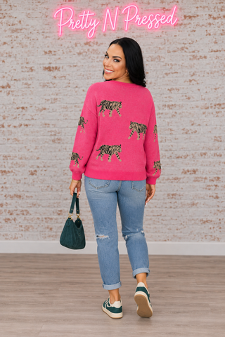 Natalie modeling the back of the Pretty and Prowling pink knit pullover with three striped tiger motifs.