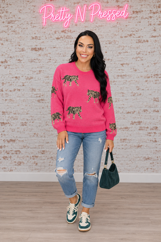 Natalie wearing the Pretty and Prowling pink knit pullover, front view showing the striped tiger motifs and ribbed trim.