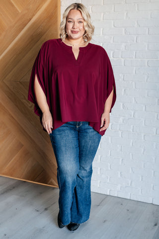 Wine Universal Philosophy poncho-style blouse, full outfit with blue jeans.