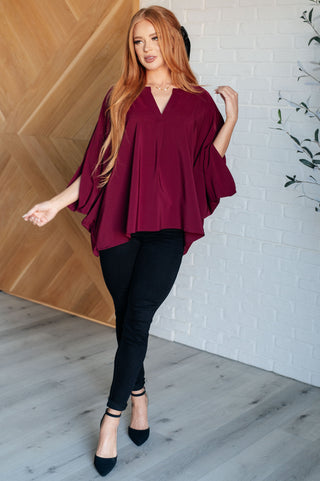 Wine Universal Philosophy poncho-style blouse, full outfit with black trousers and pointed shoes.