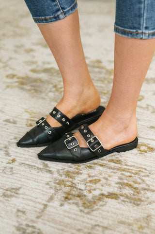 Black Soda Usual pointed-toe double-buckle flats, on-foot side view with cropped jeans.