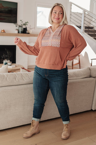 Rust Haptics Wave Hello mixed-print hoodie, full outfit with jeans and tan boots.