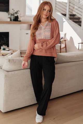Rust Haptics Wave Hello mixed-print hoodie, full outfit with black trousers.