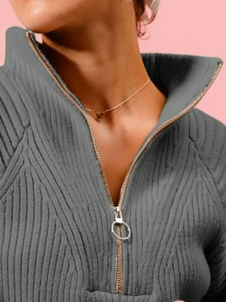 Close-up of the SO ME charcoal sweater's raised collar and ring-pull half zipper.