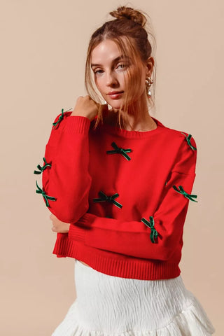 SO ME red and hunter-green bow sweater showing the long sleeves, cuffs and ribbed hem.