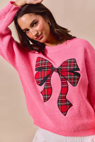 SO ME pink Christmas sweater showing the large plaid bow and ribbed round neckline.