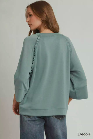 Back view of the Umgee Lagoon top showing ruffled raglan seams and a straight hem.