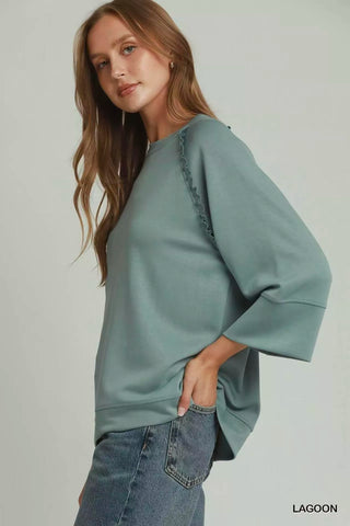 Side view of the Umgee Lagoon ruffle-trim top, worn with blue jeans.