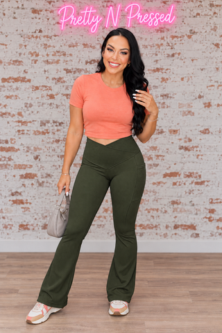 Natalie modeling dark olive Molly ribbed flare leggings with a crossover waistband and side pockets.